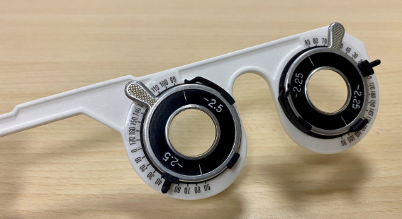 Close-up of the ophthalmic testing device fitted with trial lenses in its rotating holders